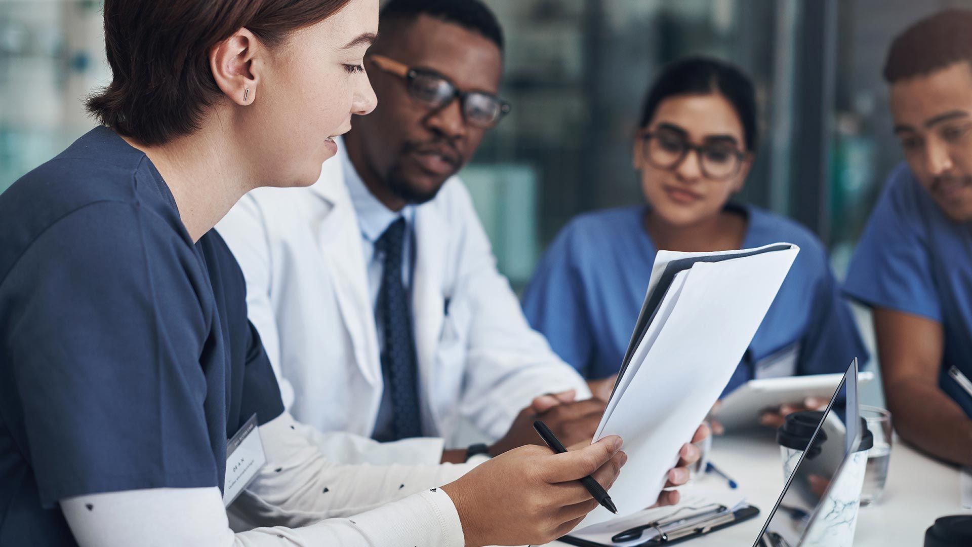 Healthcare professionals reviewing documents in a meeting.