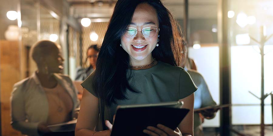 A professional reviewing information on a tablet in a modern office.