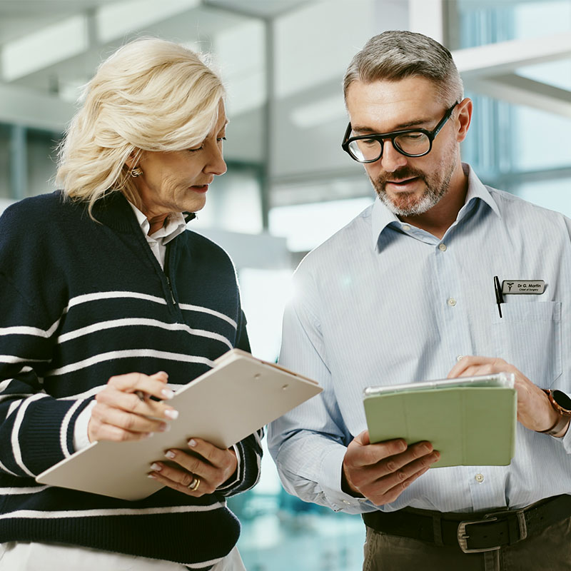 Two professionals reviewing documents in an office setting.