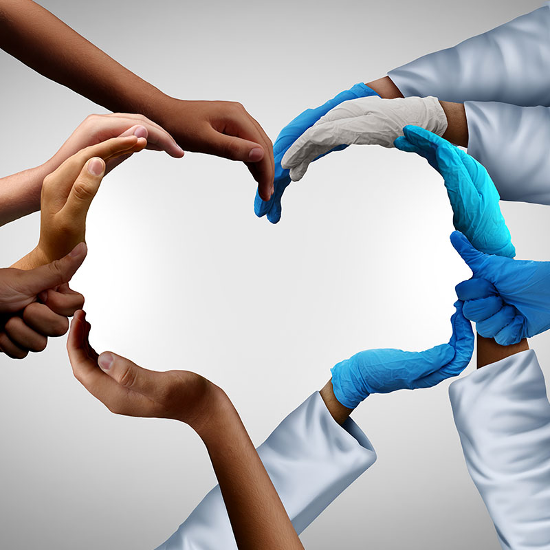 Hands forming a heart shape, some with gloves, symbolizing collaboration in healthcare.